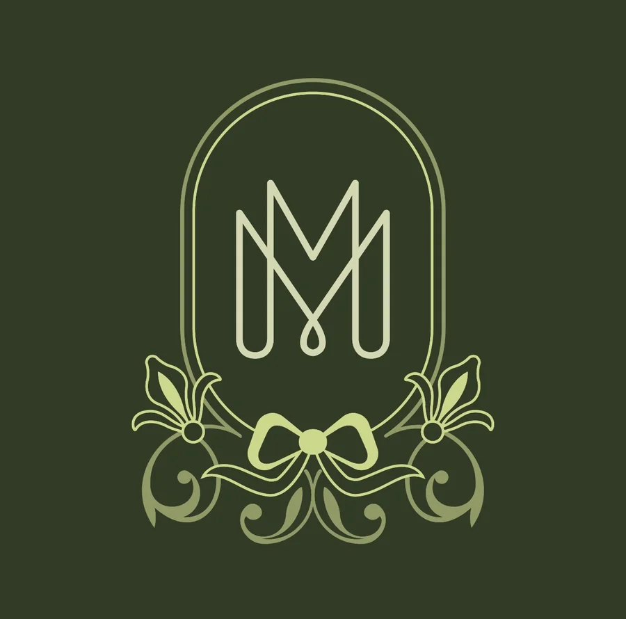 The Mimosas & Mehendi crest: an MM monogram inside an arch, tied with a bow and leaves, in pale greens on deep green